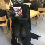 Eine als Kylo Ren verkleidete Person liest ein Star Wars Buch
