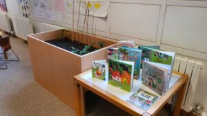 Ein Hochbeet und ein Tisch mit Kinderbüchern über Gartenarbeit